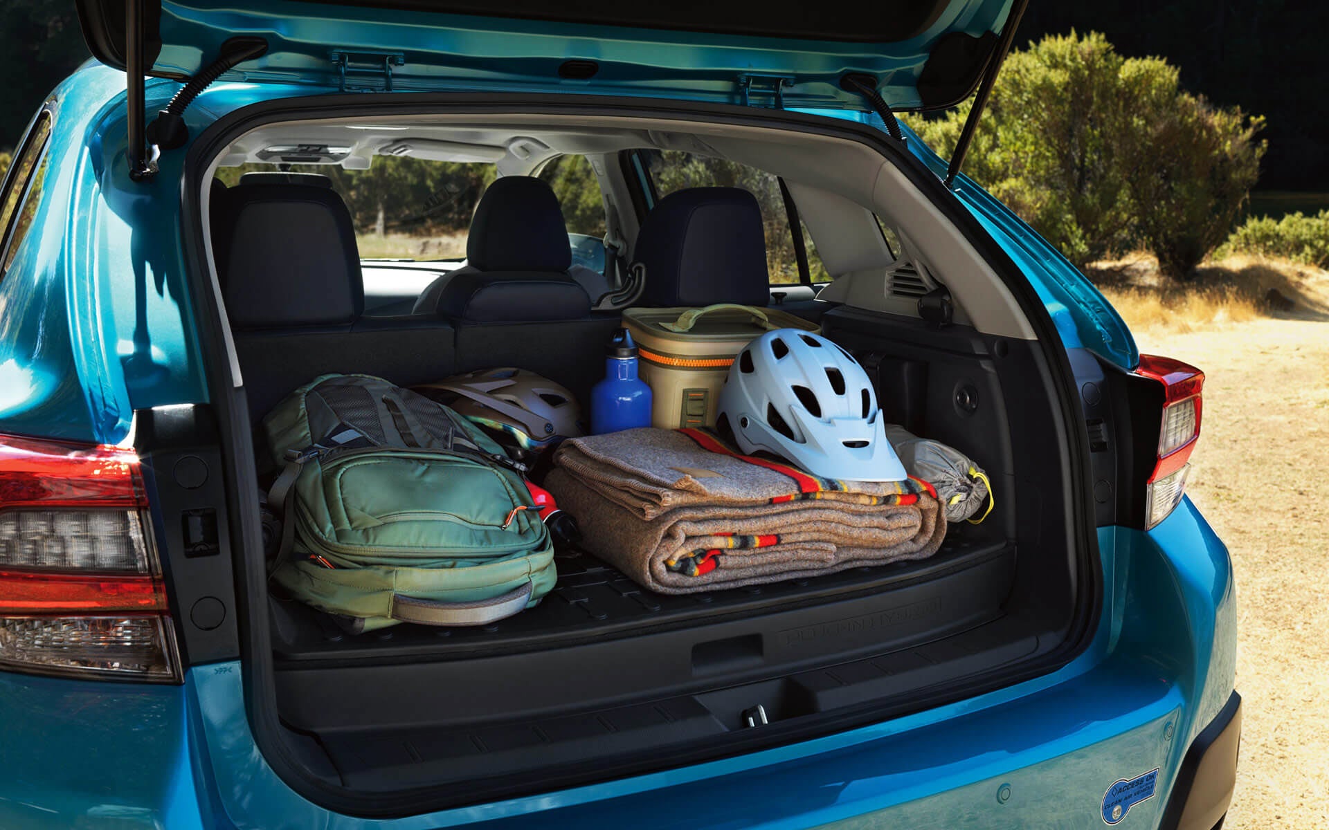 A backpack, blanket, and bike helmet in the rear cargo area of a Crosstrek Hybrid | Jim Keras Subaru in Memphis TN
