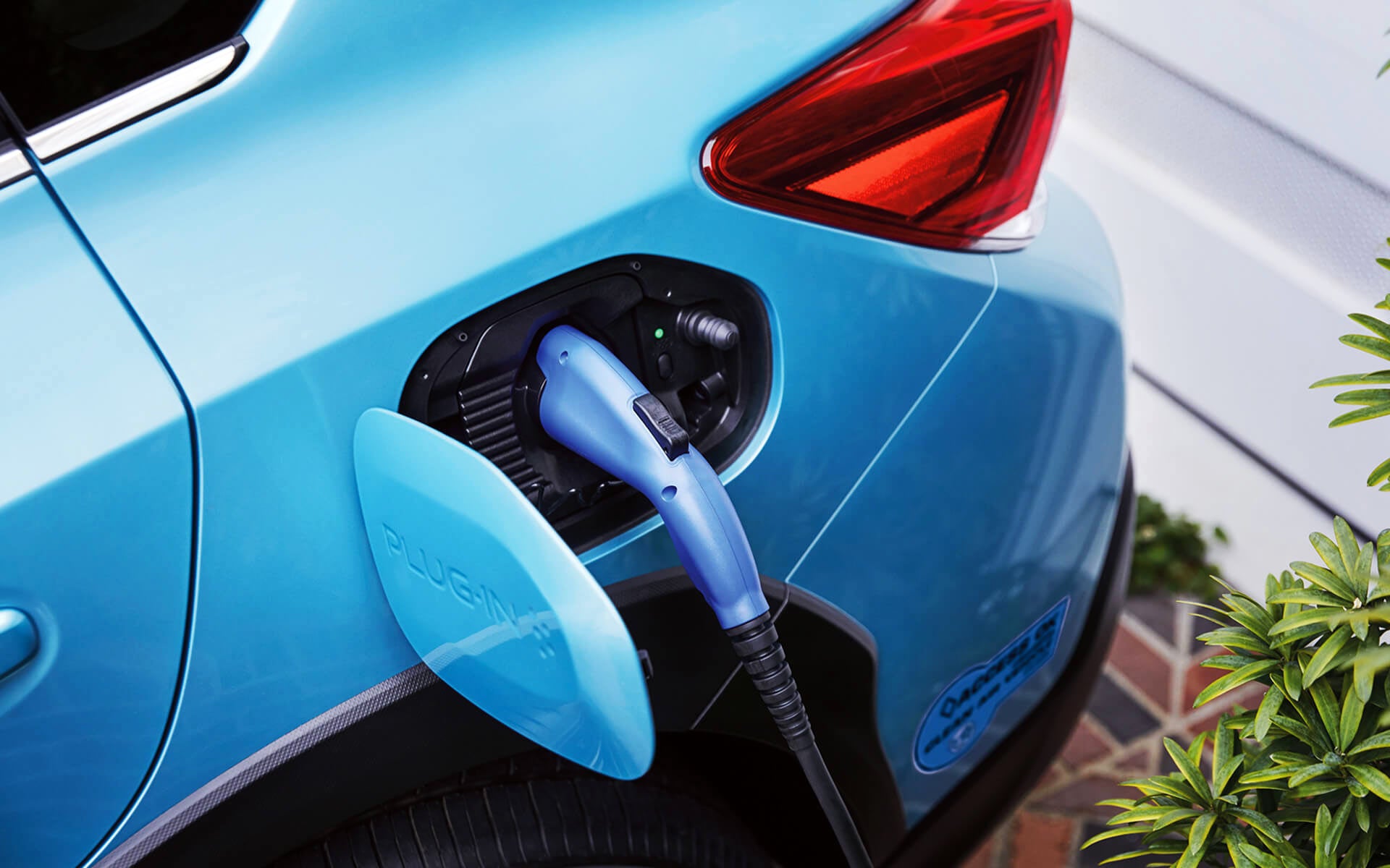 A close-up of the Subaru Crosstrek Hybrid's charging port with charging cable plugged in | Jim Keras Subaru in Memphis TN