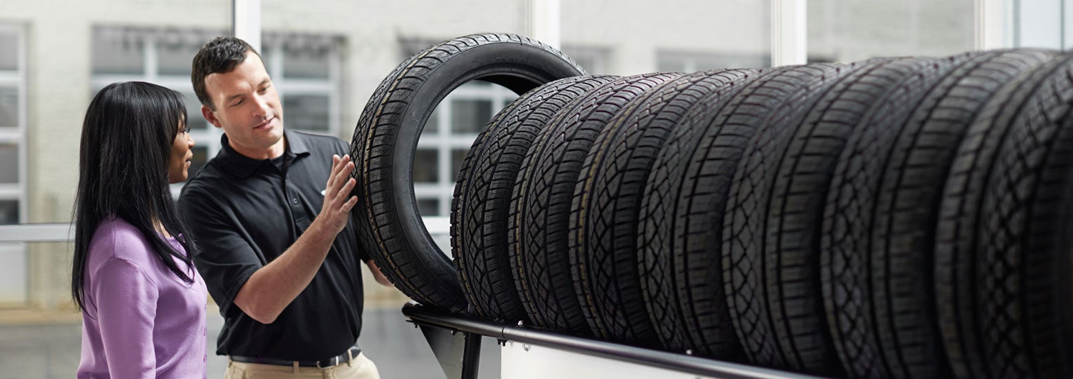 Subaru service representative showing customer a tire. | Jim Keras Subaru in Memphis TN